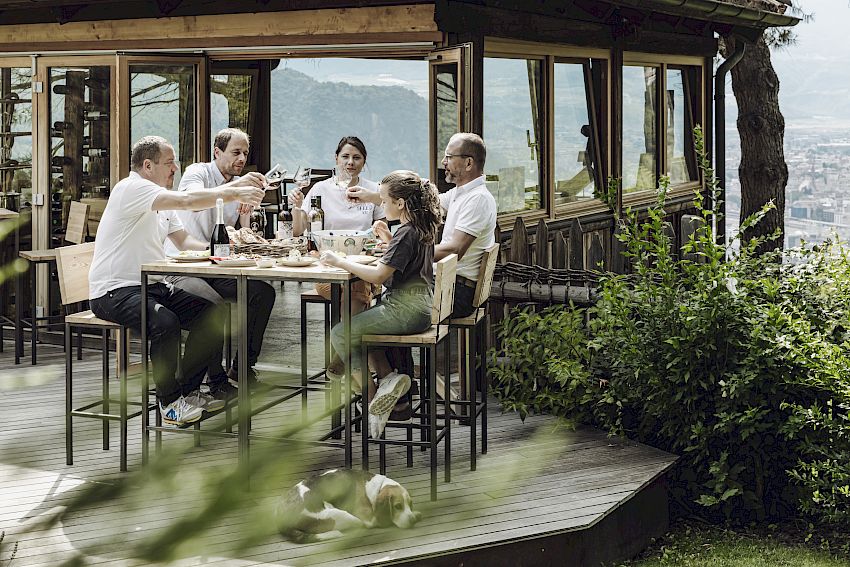 Weinverkostung auf einer Terrasse mit Bergblick