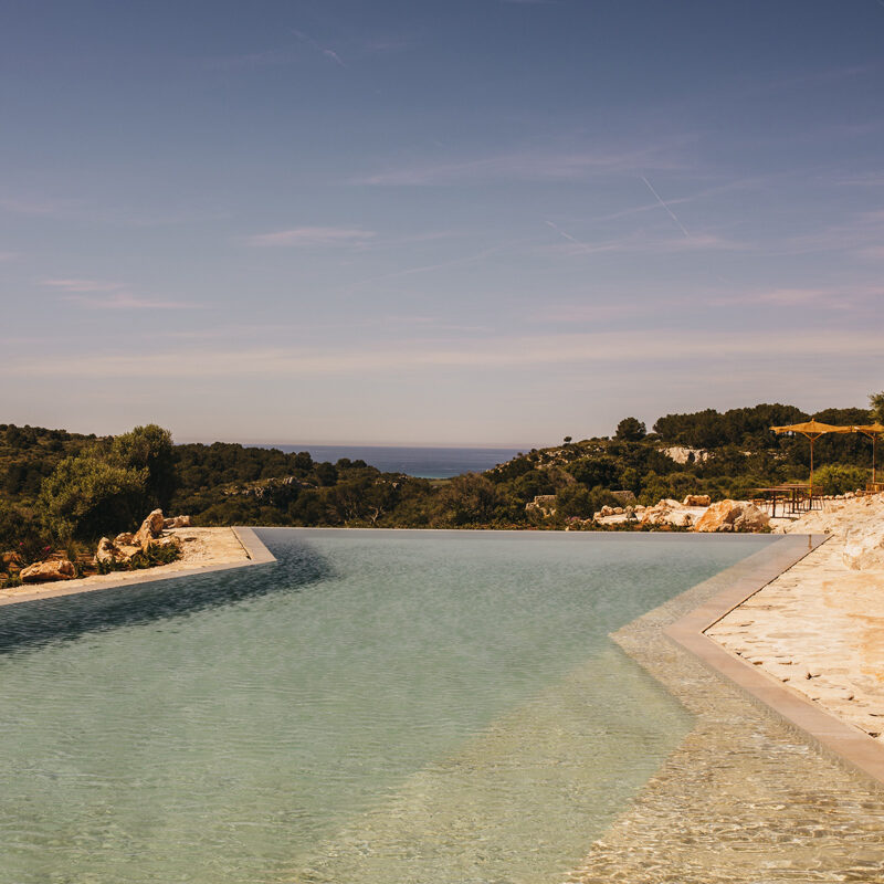 Menorca — Pool mit Blick aufs Meer, Trockenmauern und offenes Farmland rund um Son Blanc